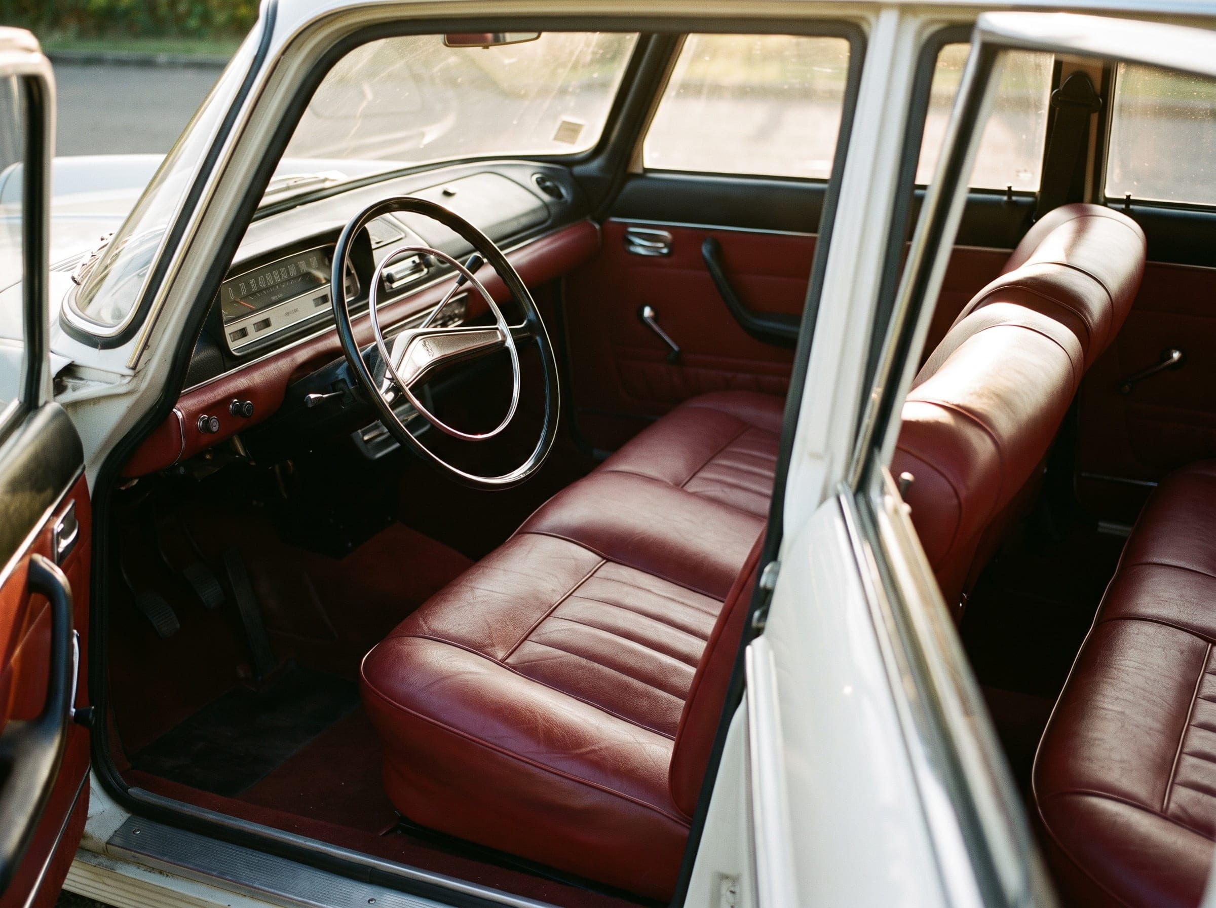 Rote Sitzbänke und ein verchromtes Lenkrad in einem Peugeot 404